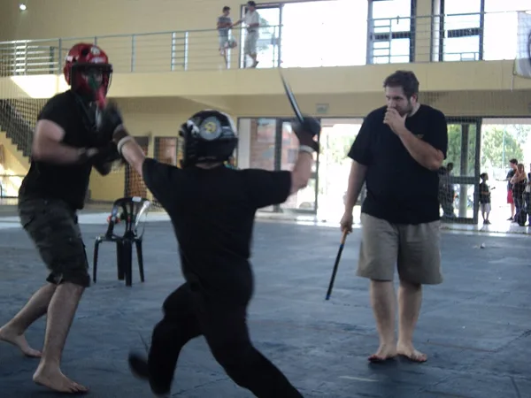Combate num torneio de eskrima, com capacete e proteções.